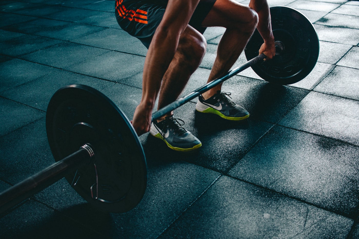 Lifter setting up for a deadlift on a dark gym floor
